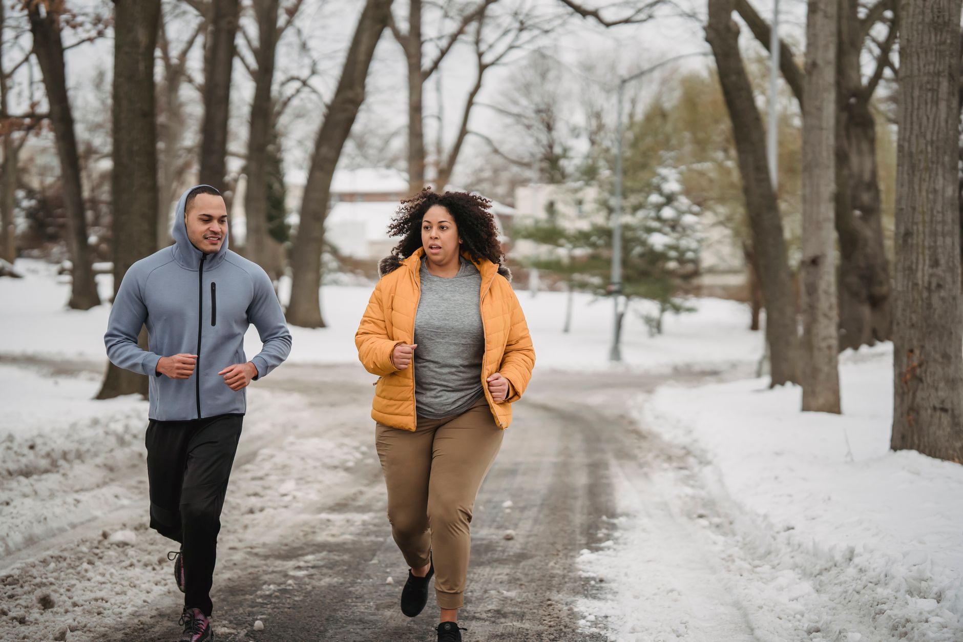 Coureur habillé en pelure d'oignon courant sur un sentier enneigé au Québec en hiver