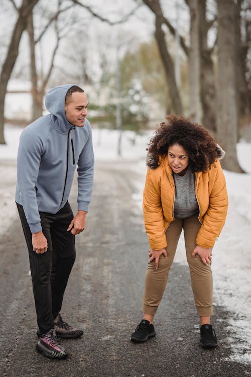 Tired black woman with trainer after workout