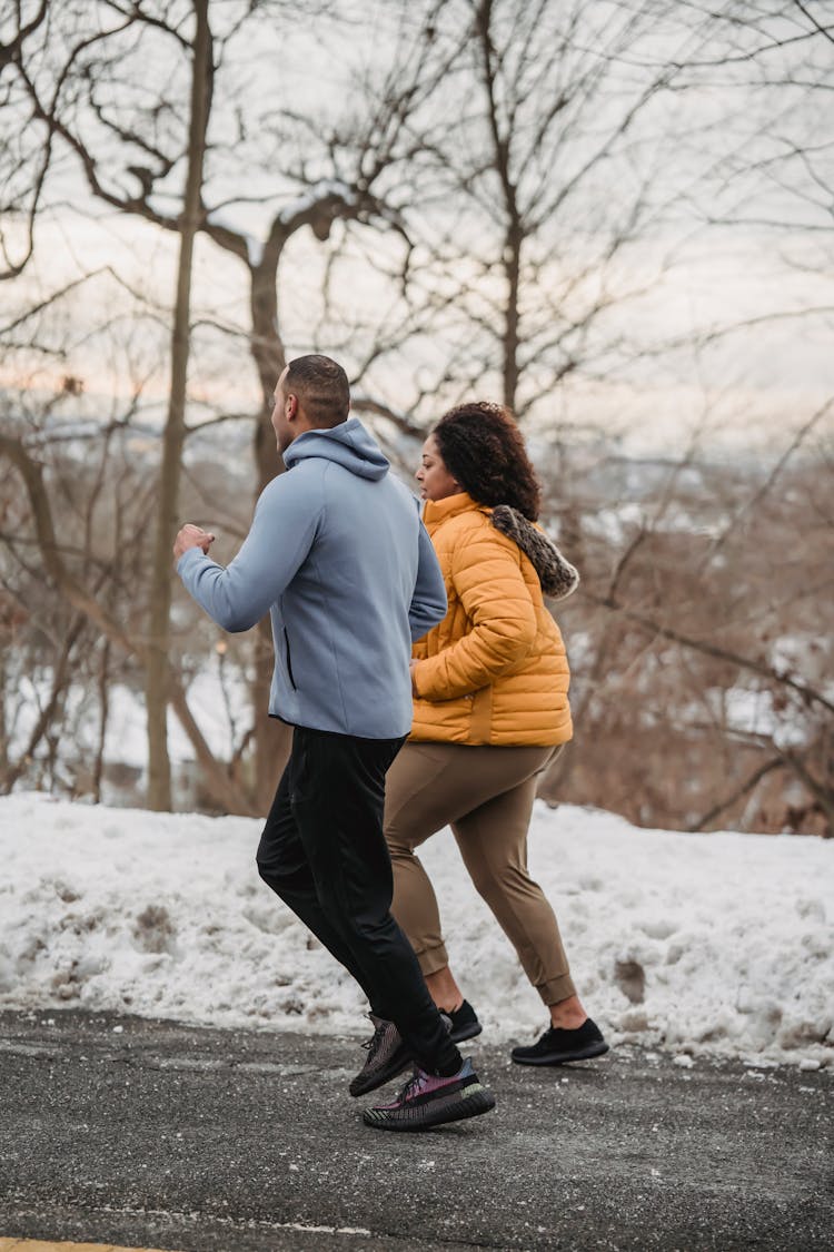 Trainer Helping Plump Black Woman To Do Running In Park