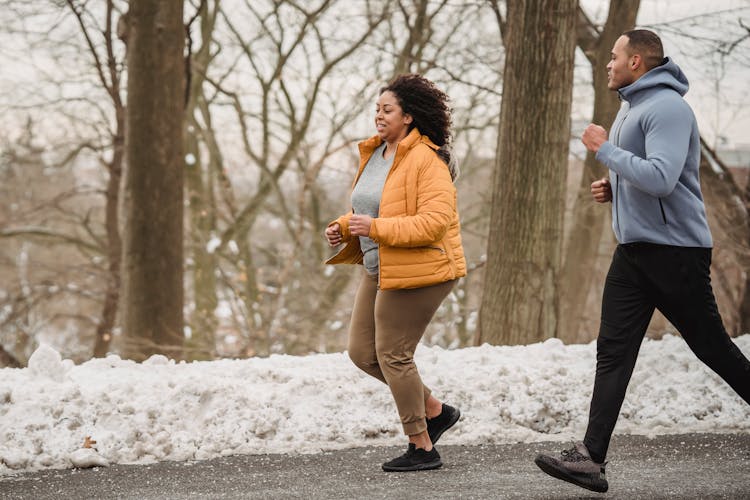 Sporty Black Woman Running With Instructor On Street