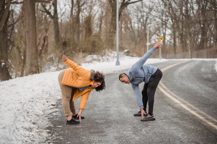 Black Couple Stretching Before Training On Road