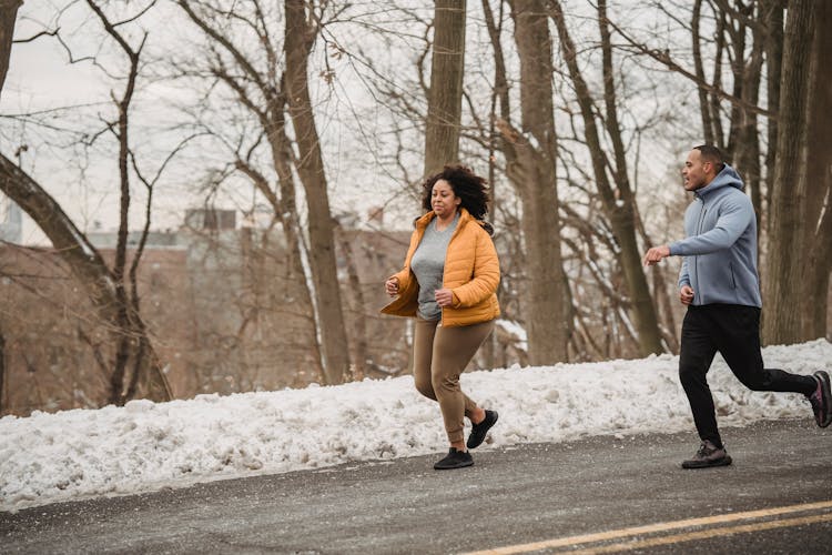 Overweight Black Woman Running With Trainer During Winter Time