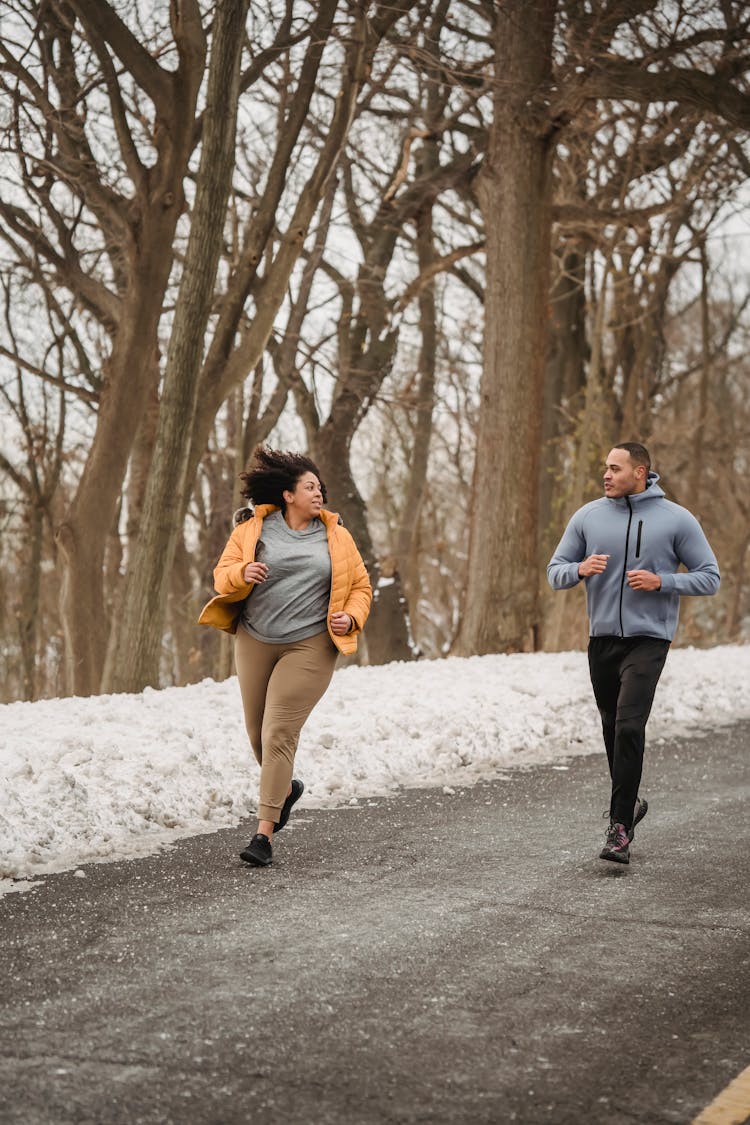 Sportive Black Couple Running In Winter Park