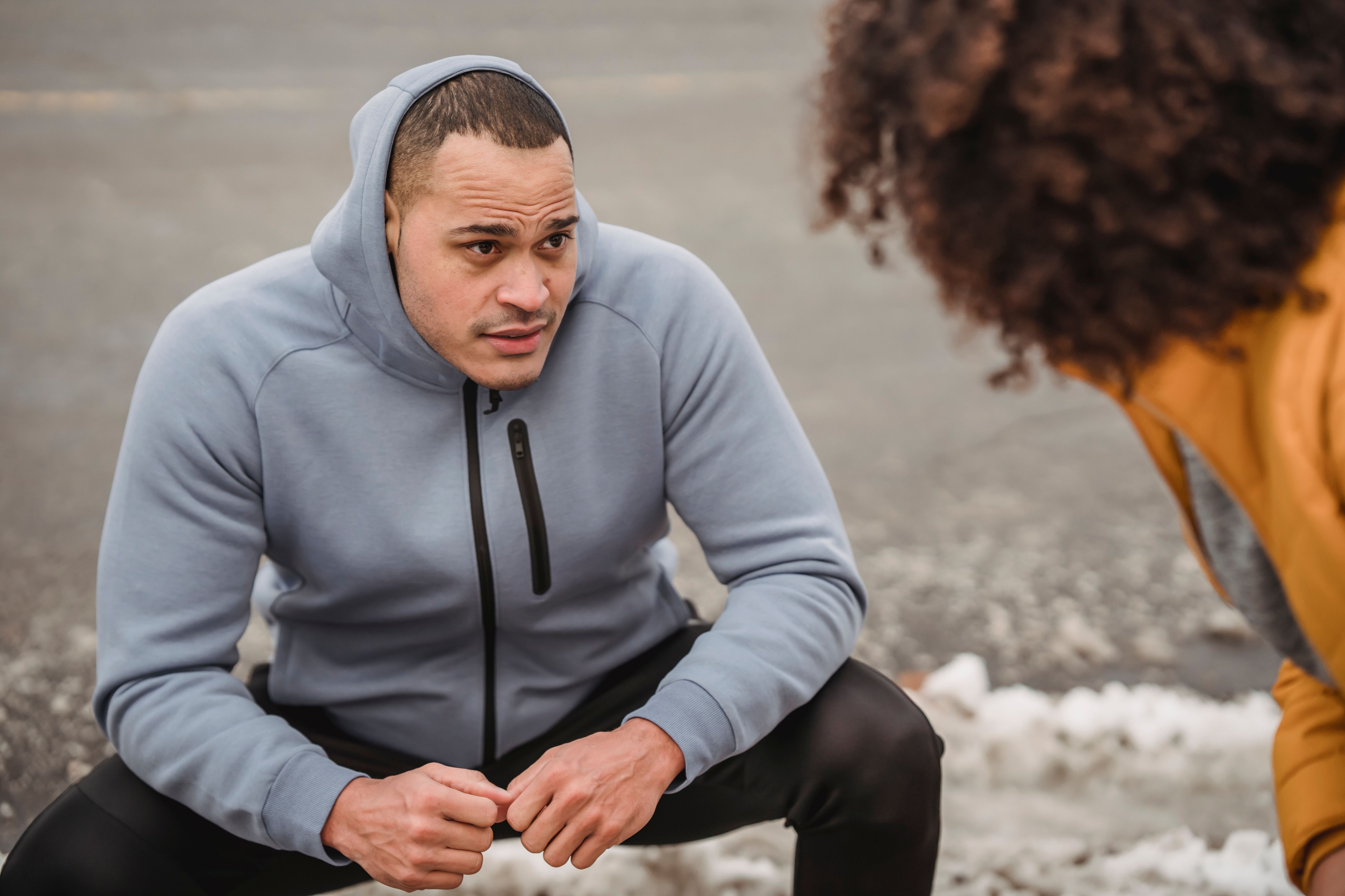 Sporty individual in activewear focuses before winter exercise, snow visible.