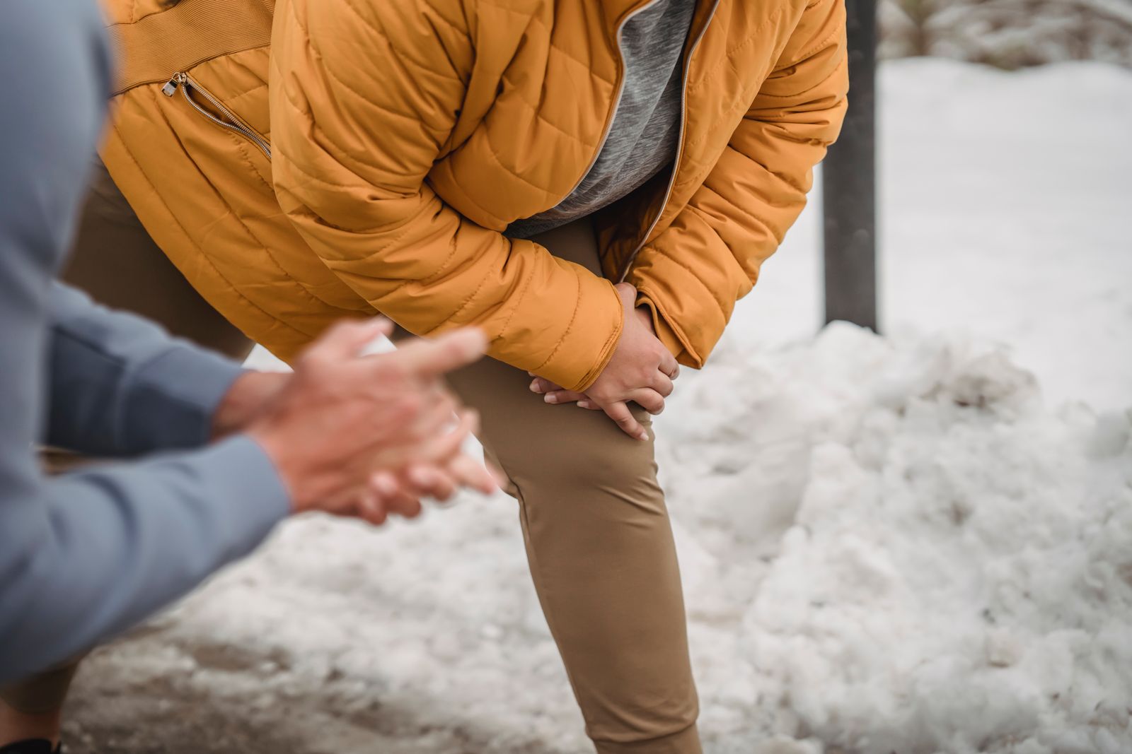 Person adjusting a knee brace before walking outdoors