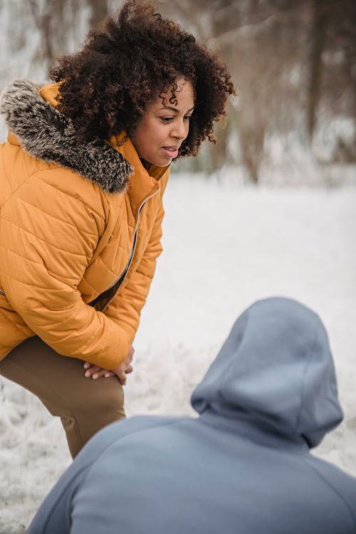 Free Overweight African American female advising with crop anonymous trainer while doing lunges in winter park in daytime Stock Photo