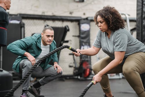 Free Determined black plump woman exercising with battle ropes in gym Stock Photo