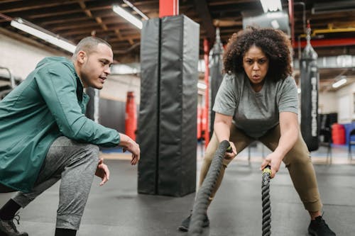 Free Determined black woman exercising with battle ropes in gym Stock Photo