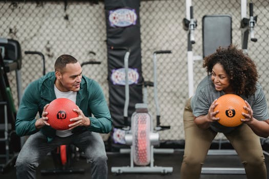 Diverse man and plump woman exercising with bright balls in sport club with gym equipment