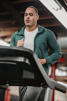 Focused man running on a treadmill, embodying fitness and determination in a modern gym environment.