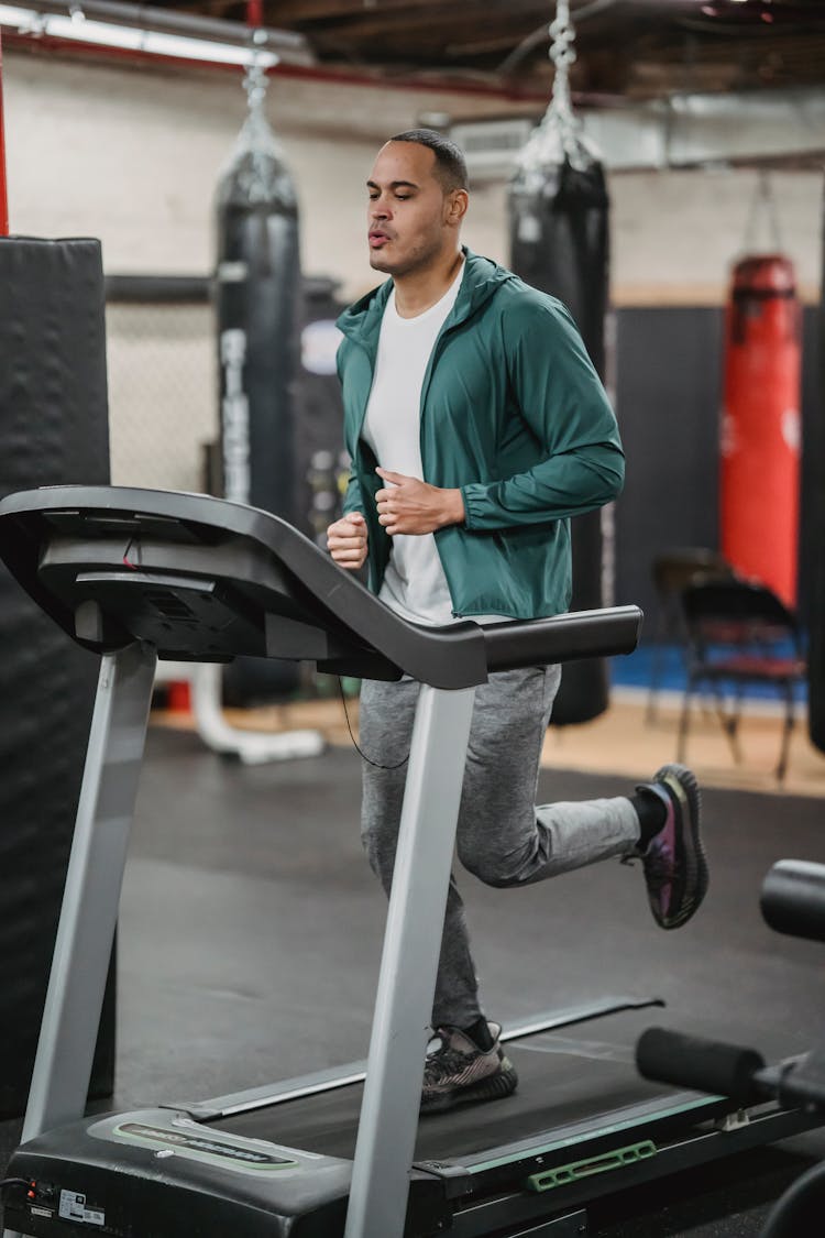 Fit Focused Man Running On Treadmill In Sport Club