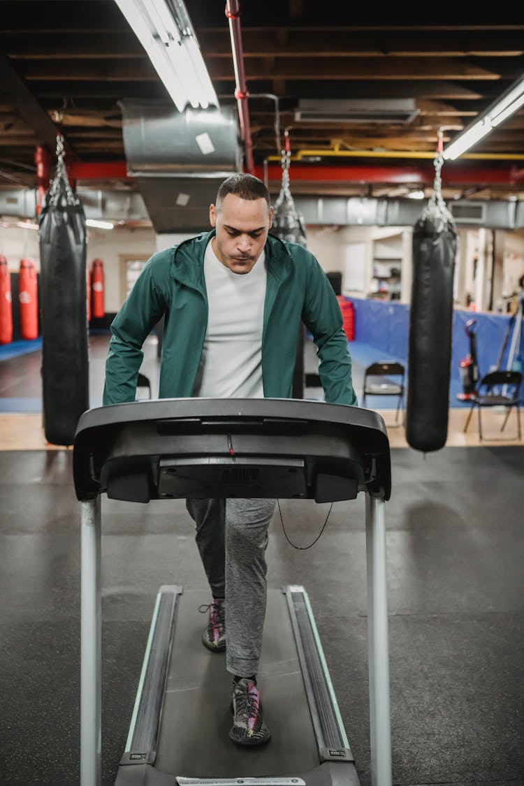 Energetic Man Walking On Treadmill In Gym