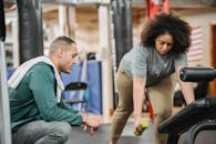 Multiethnic man and woman training together in gym