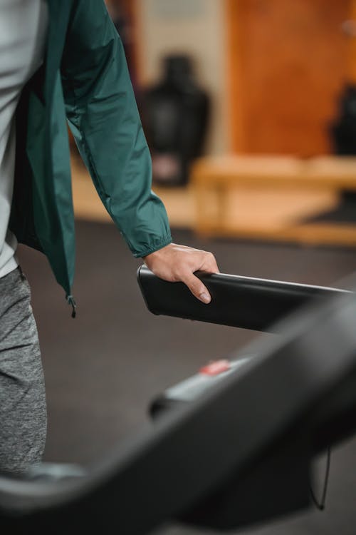 Free Man using treadmill while jogging in gym Stock Photo