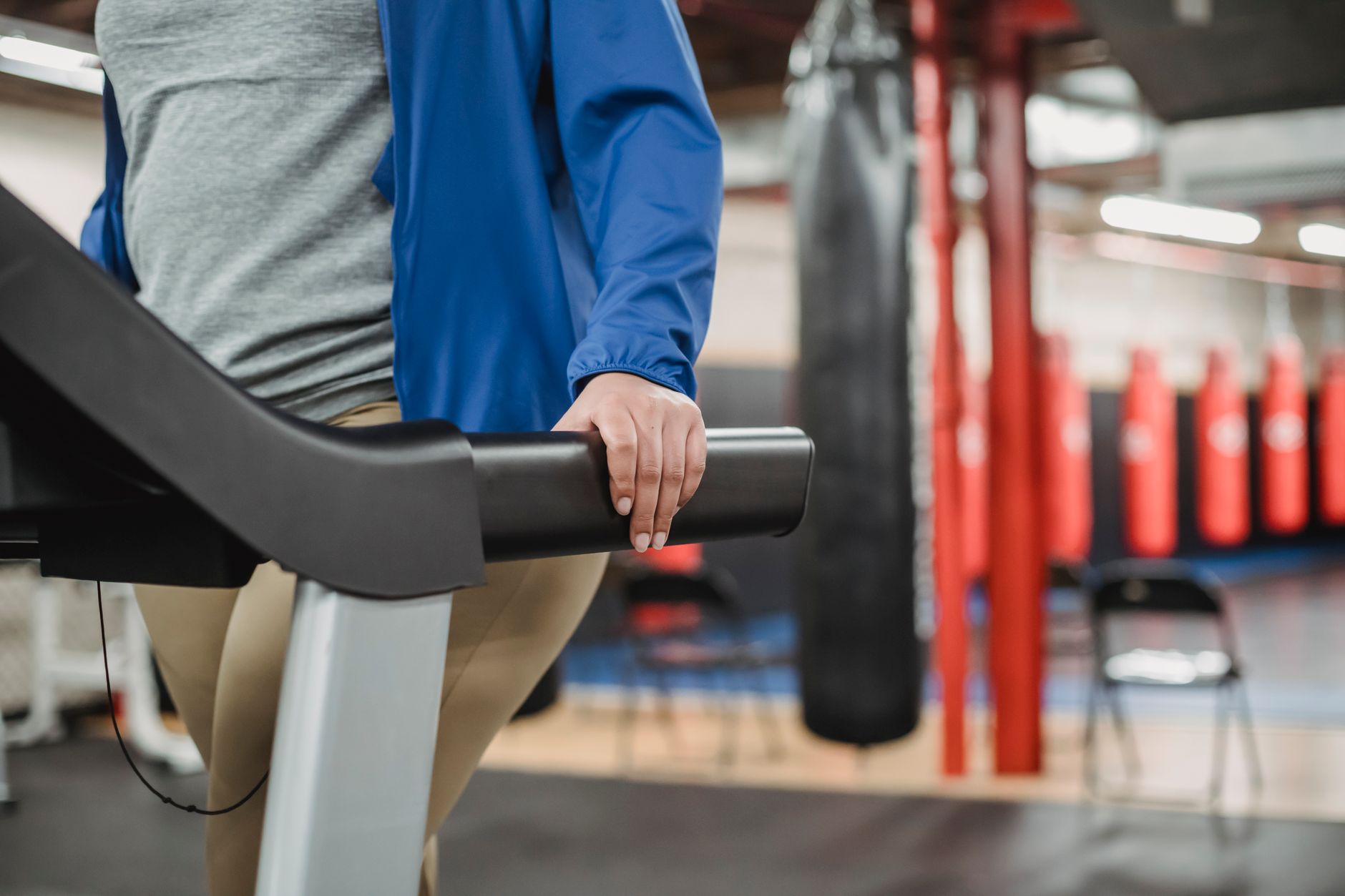 Side view of crop unrecognizable curvy female training on treadmill in modern fitness center