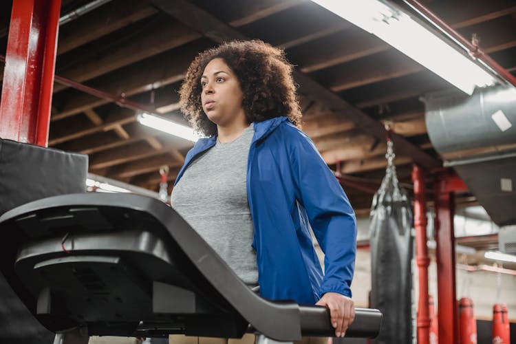 Serious Black Woman On Treadmill In Modern Gym