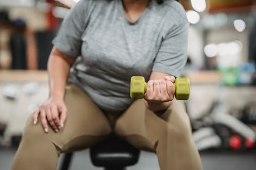 Curvy black woman doing exercises with dumbbells Stock Photo