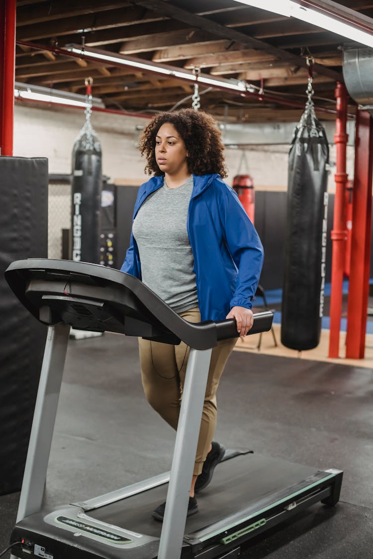 Black Woman Standing On Treadmill During Cardio Workout