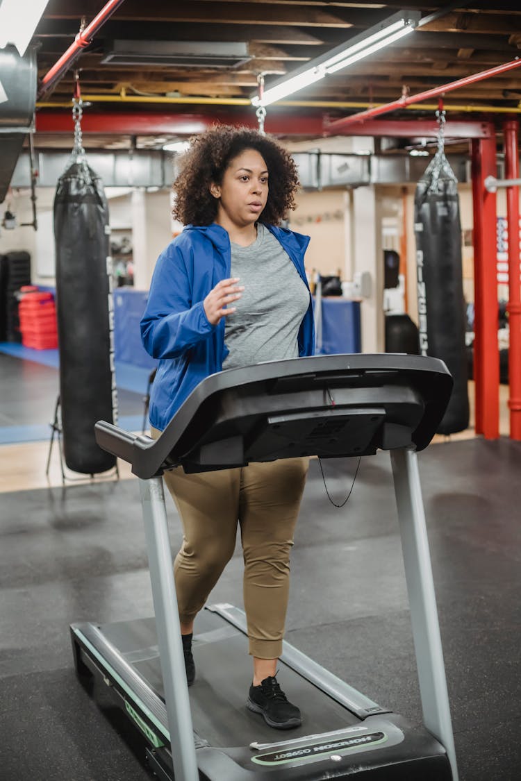 Pensive Woman Running On Treadmill In Gym