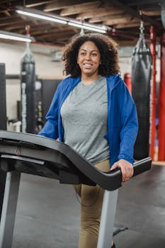 Smiling woman in sportswear working out on a treadmill, promoting a healthy lifestyle.