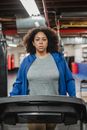 Serious woman walking on treadmill during workout