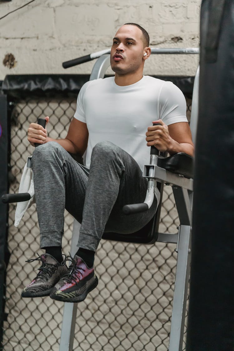 Serious Young Man Working Out Muscle In Gym