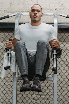 Full body of focused sportive man training muscles on exercise machine in fitness center