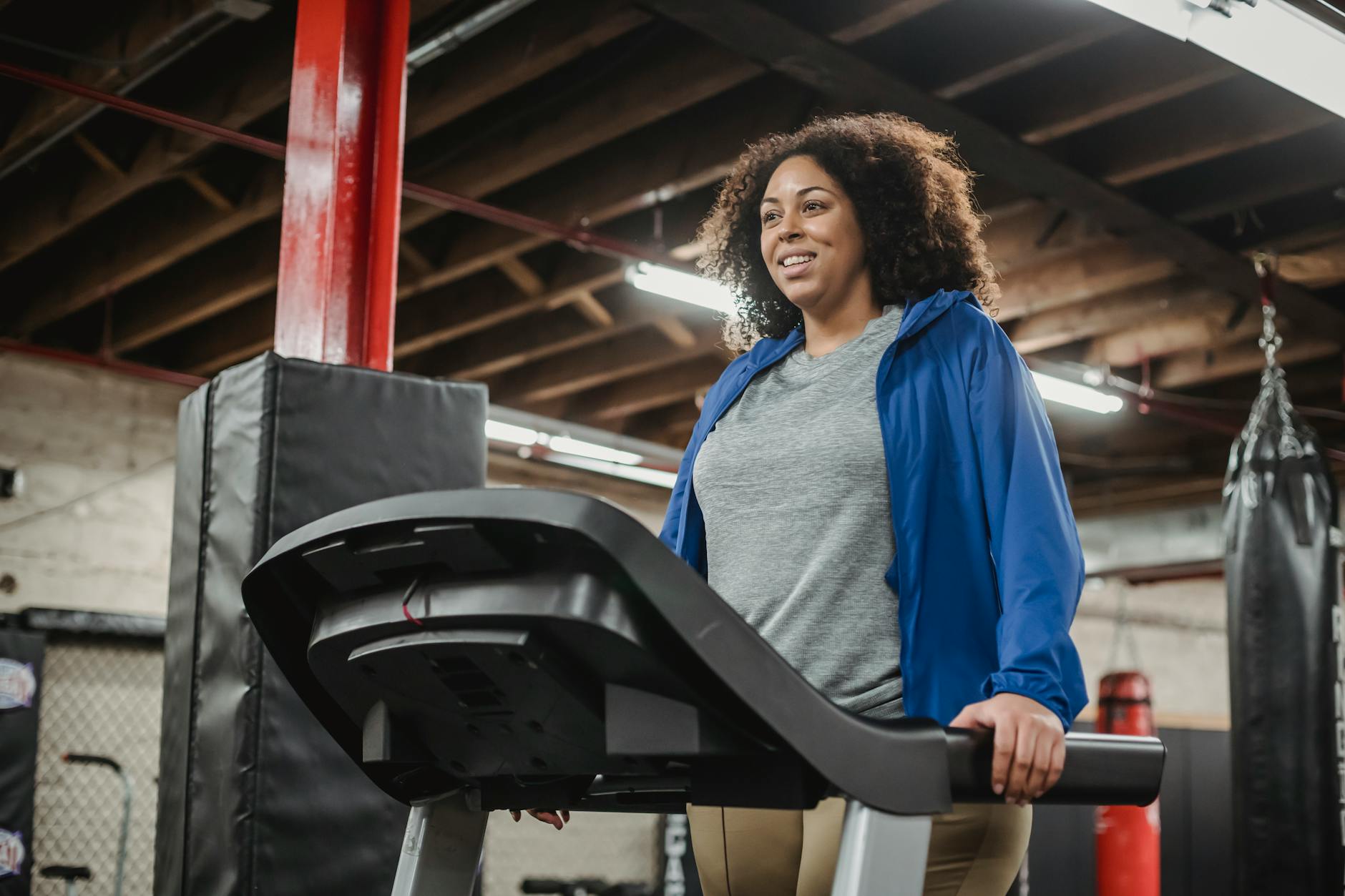 Smiling black woman standing on treadmill