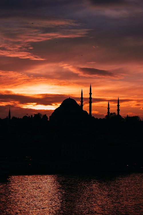 Silhouette of a Mosque and Trees During Dramatic Sunset Sky