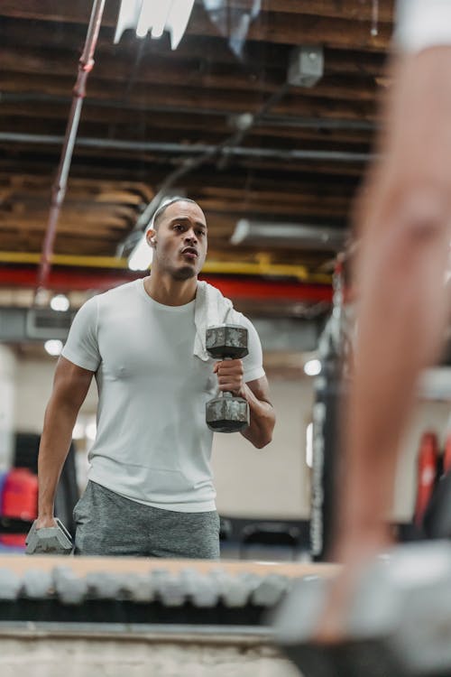 Free Black man training with dumbbells in gym Stock Photo