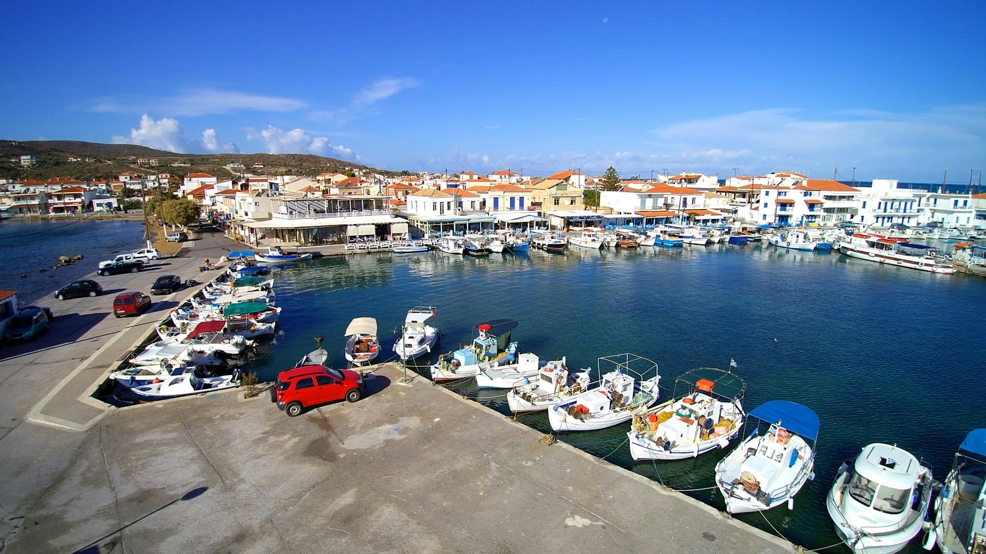 Aerial view of Elafonisos harbor, Greece with boats by dock on a sunny day.