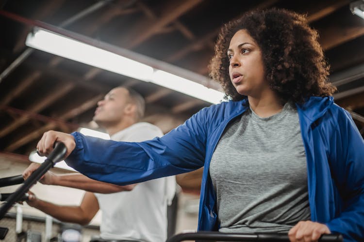 Concentrated Plump Black Woman Cycling In Gym