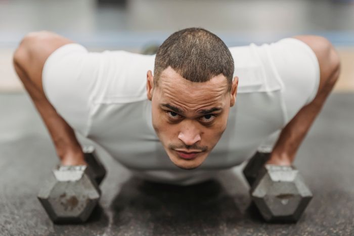Athlete doing push-ups on dumbbells