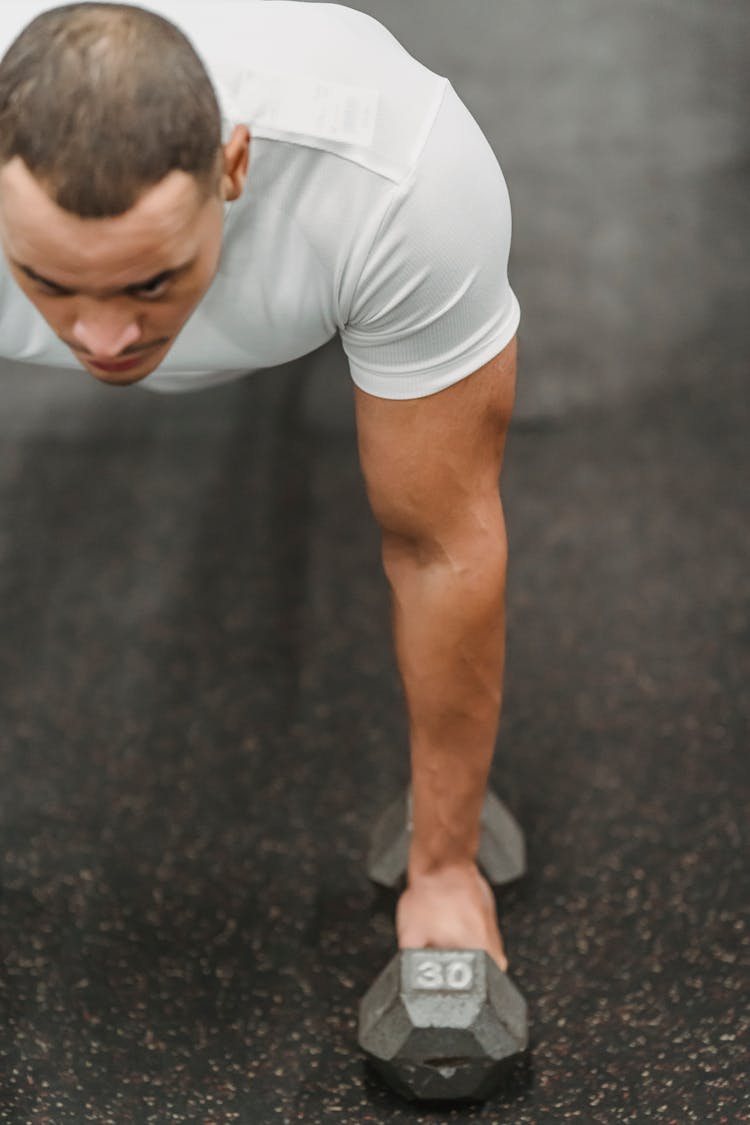 Strong Ethnic Man Doing Plank Exercise With Dumbbell