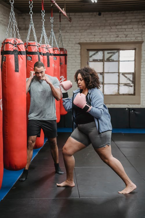 Free Ethnic male coach showing hit to concentrated black woman Stock Photo