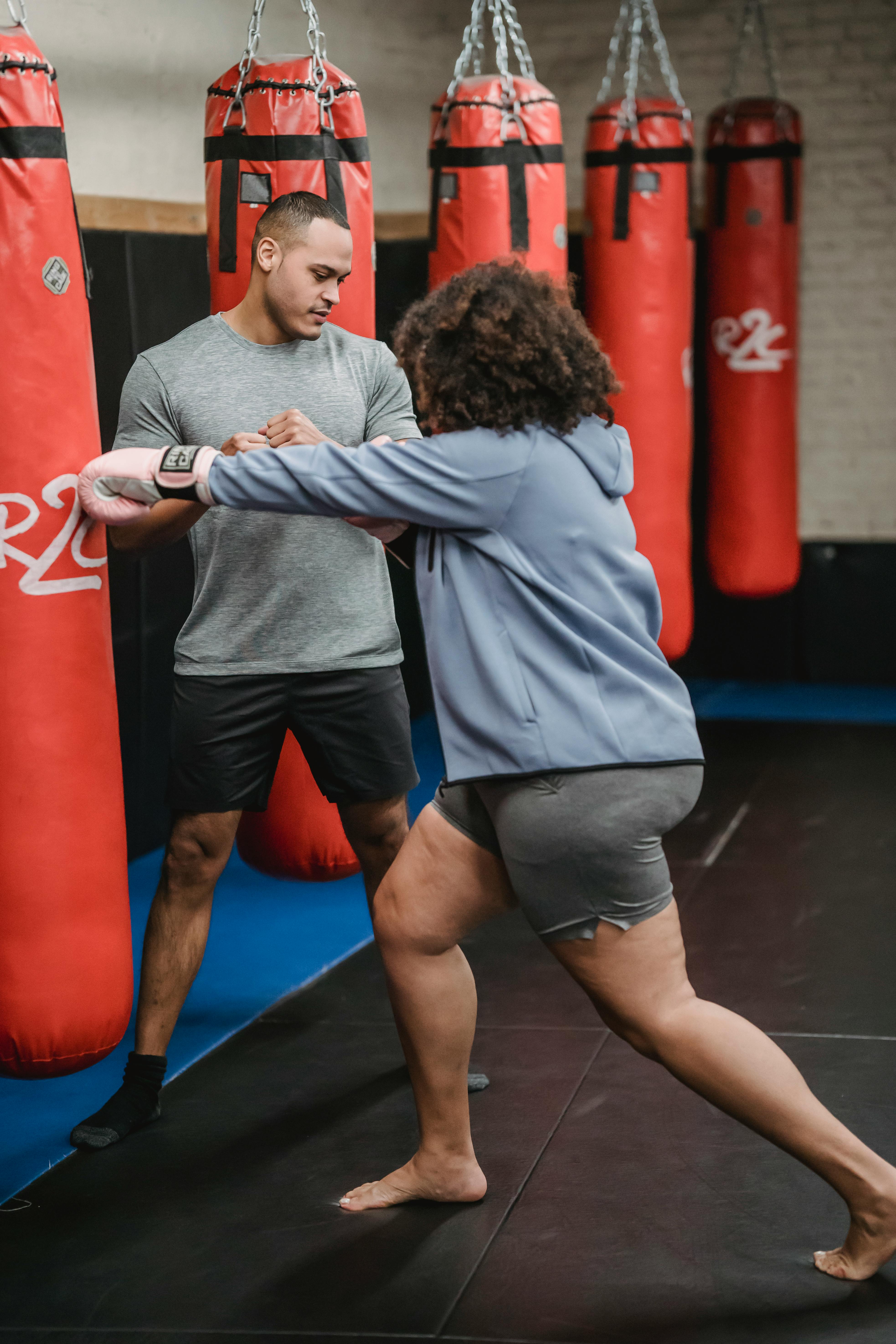 Powerful black woman punching heavy bag during workout  Free Stock Photo