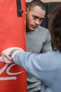 Focused ethnic male trainer with woman in gym