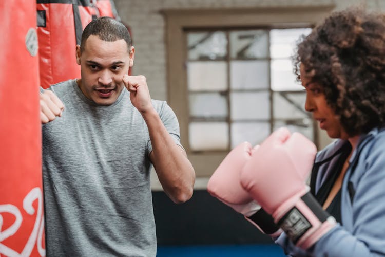 Serious Ethnic Coach Showing Punch To Black Woman