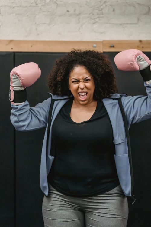 Free Strong African American female fighter with open mouth and frowning face looking at camera in gymnasium Stock Photo