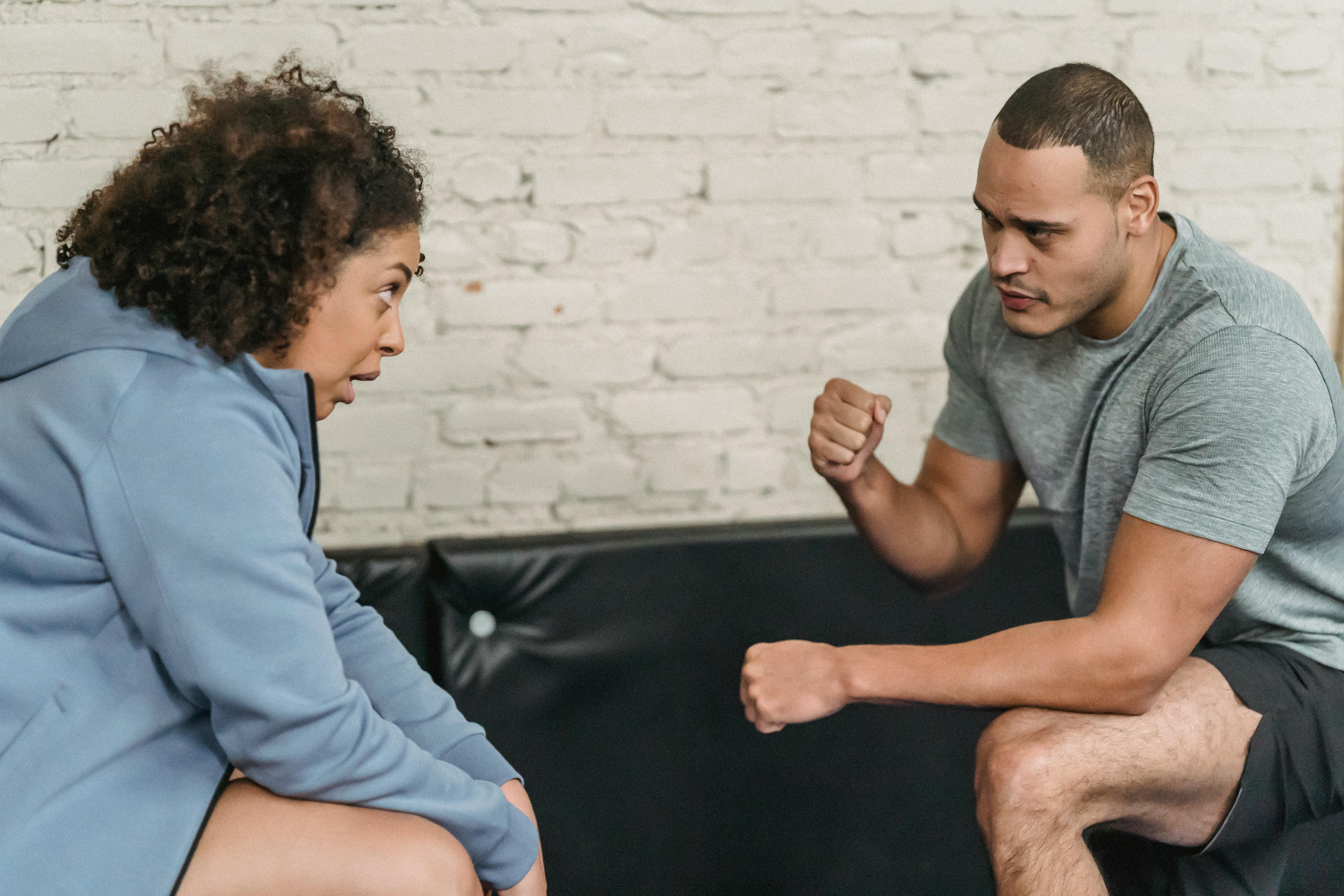 black trainer teaching woman to do exercise