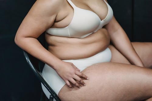 Faceless plus size lady on chair in studio