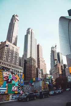 Dynamic street view of New York City's skyscrapers and colorful graffiti in daylight.