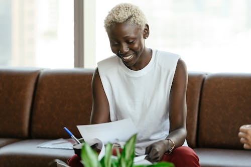 Femme En Débardeur Blanc Tenant Un Stylo Vert