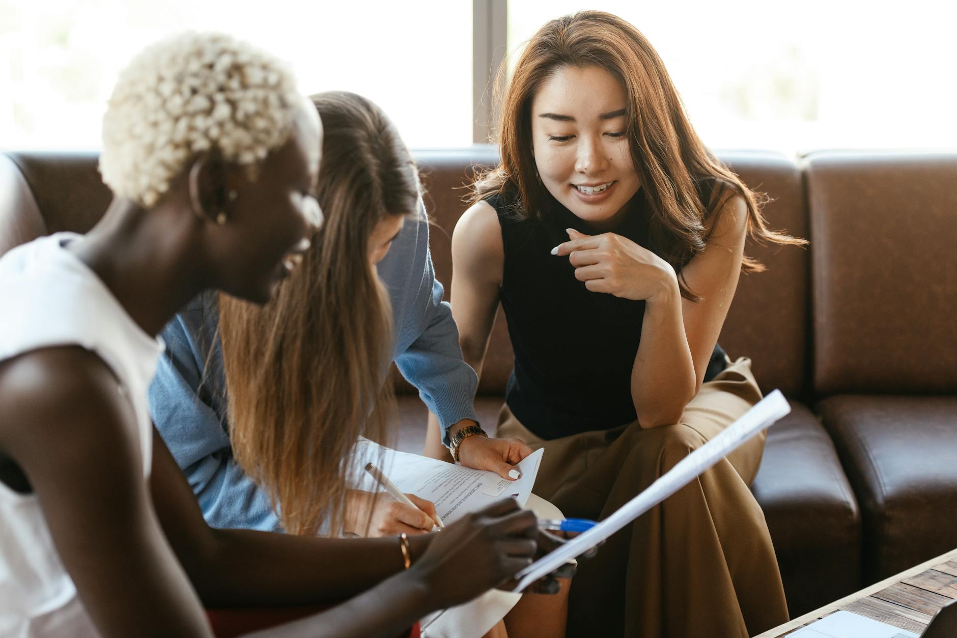 Why Most Entrepreneurs Seek Business Mentors A diverse group of women engage in a collaborative business meeting in an office setting.