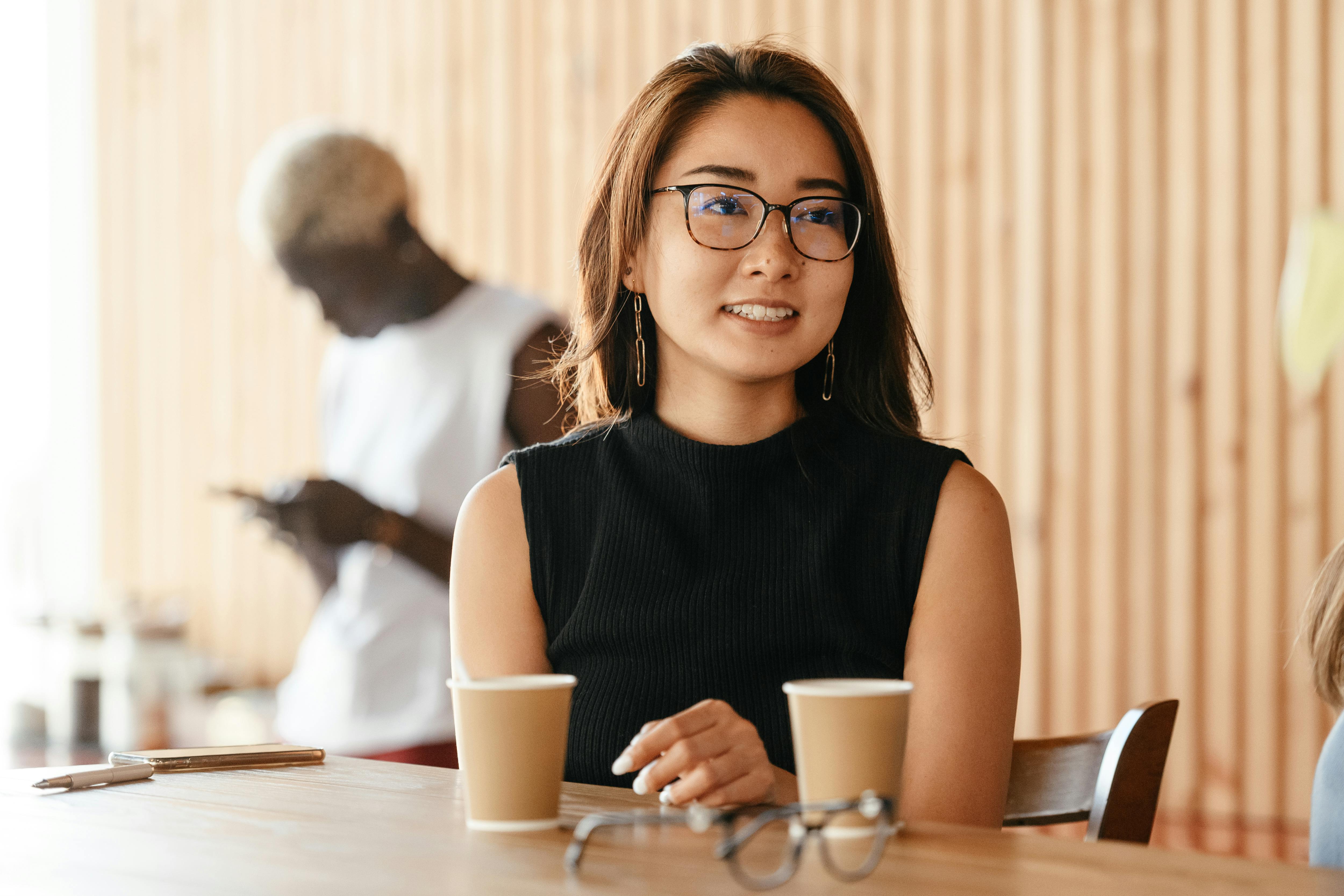 young pleasant asian woman in eyeglasses in cafe