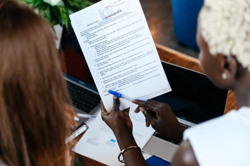 Free From above of crop anonymous business colleagues working with important documents while discussing strategy in office Stock Photo