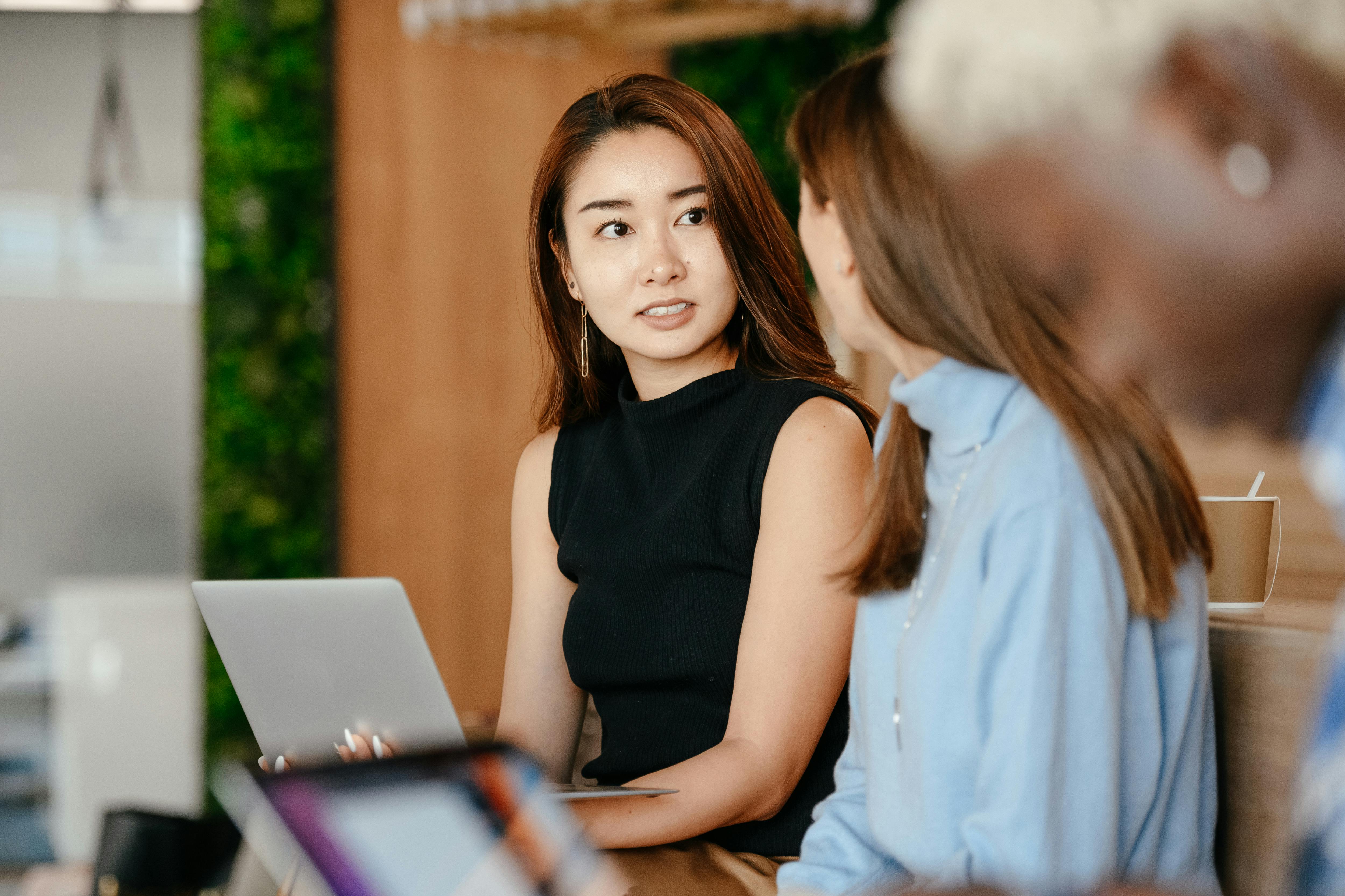 asian woman discussing business plan with diverse colleagues