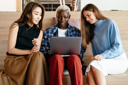 Free Group of young glad multiracial business partners in trendy outfits working with netbook in modern workspace Stock Photo