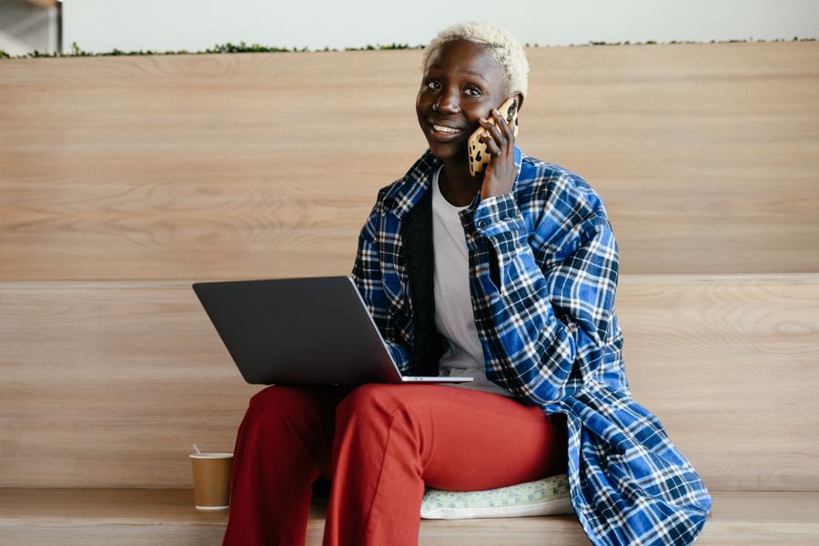 Person using a phone and laptop for online communication