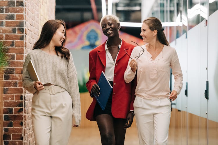 Diverse Successful Businesswomen Smiling And Walking Together In Modern Workplace